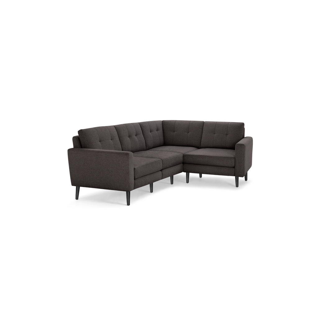 Dark gray L-shaped sectional sofa with tufted back cushions and tapered black legs, showcasing modern mid-century design.