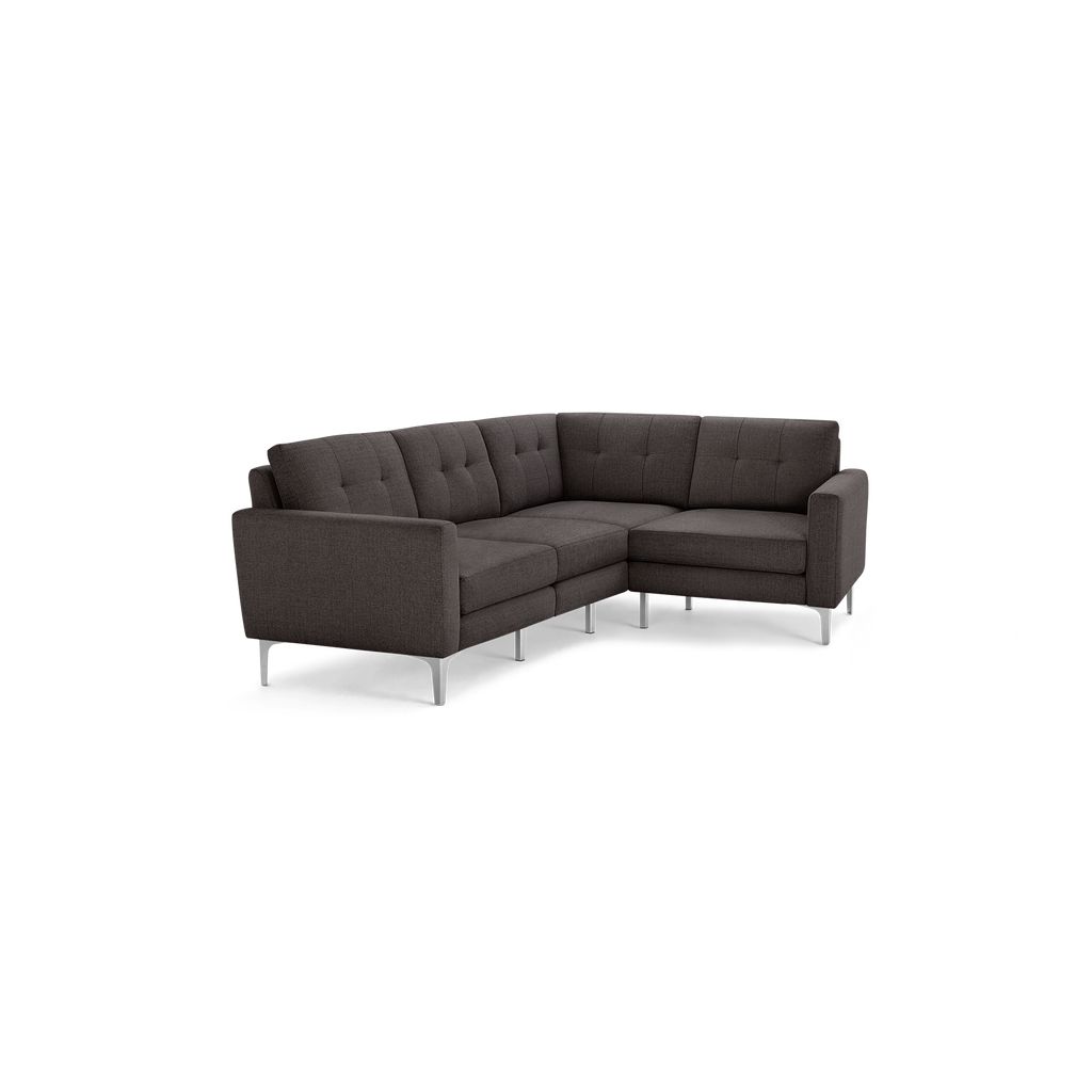 Dark gray fabric upholstered L-shaped sectional sofa with tufted back cushions and slim silver metal legs.