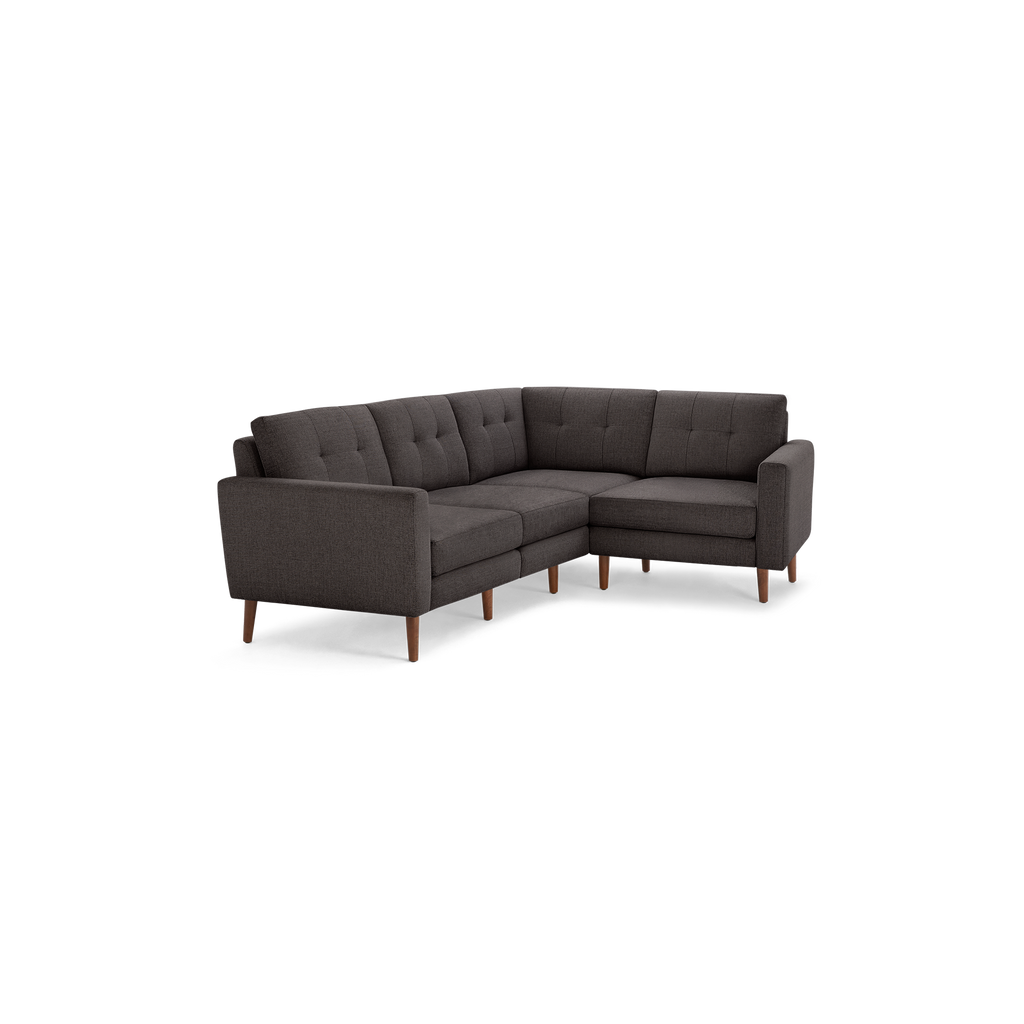 Dark gray L-shaped sectional sofa with tufted cushions, straight arms, and wooden tapered legs, modern and compact design.