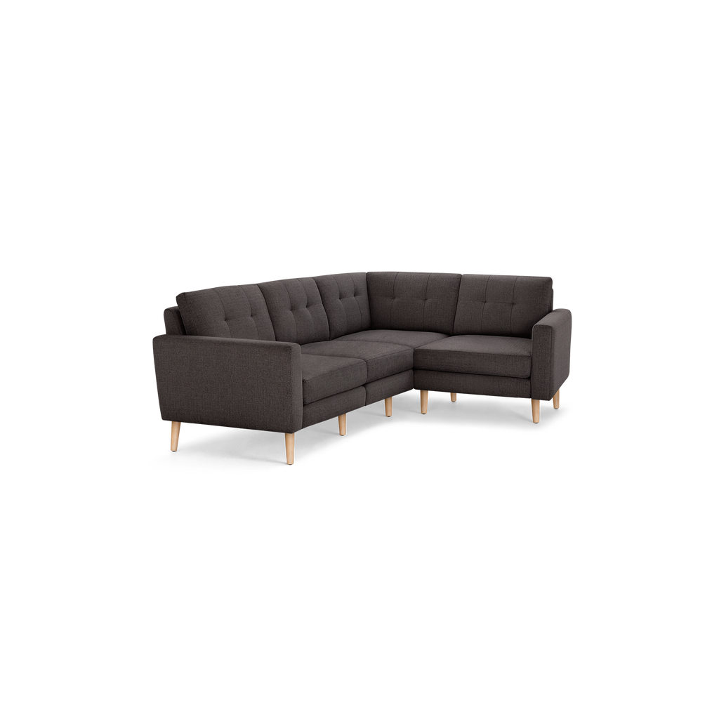 Modern dark gray fabric sectional sofa with tufted back cushions and light wooden legs, featuring an L-shaped design.