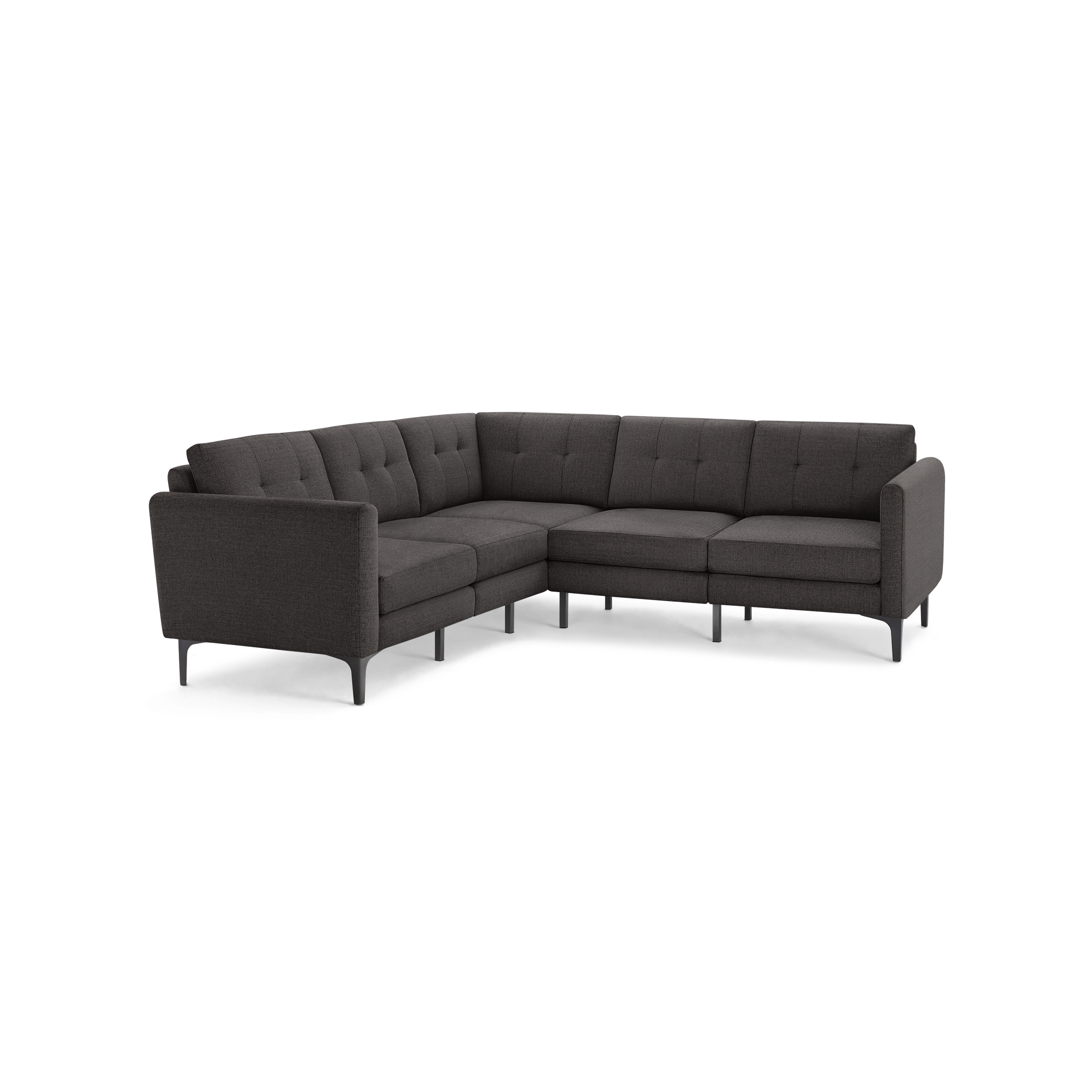 Dark gray L-shaped sectional sofa with tufted cushions, slim armrests, and modern black legs, isolated on black background.
