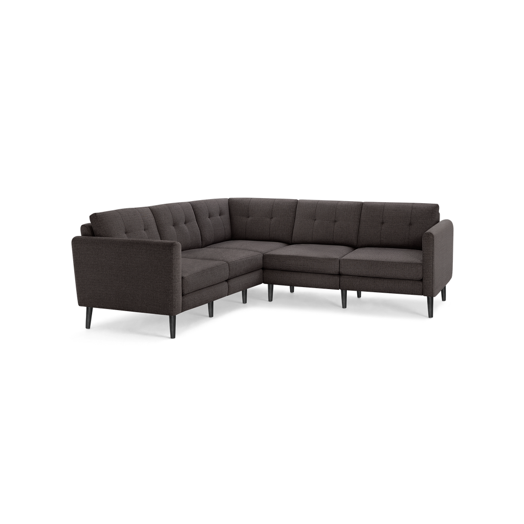 Dark gray fabric L-shaped sectional sofa with button-tufted back cushions and slim black wooden legs.