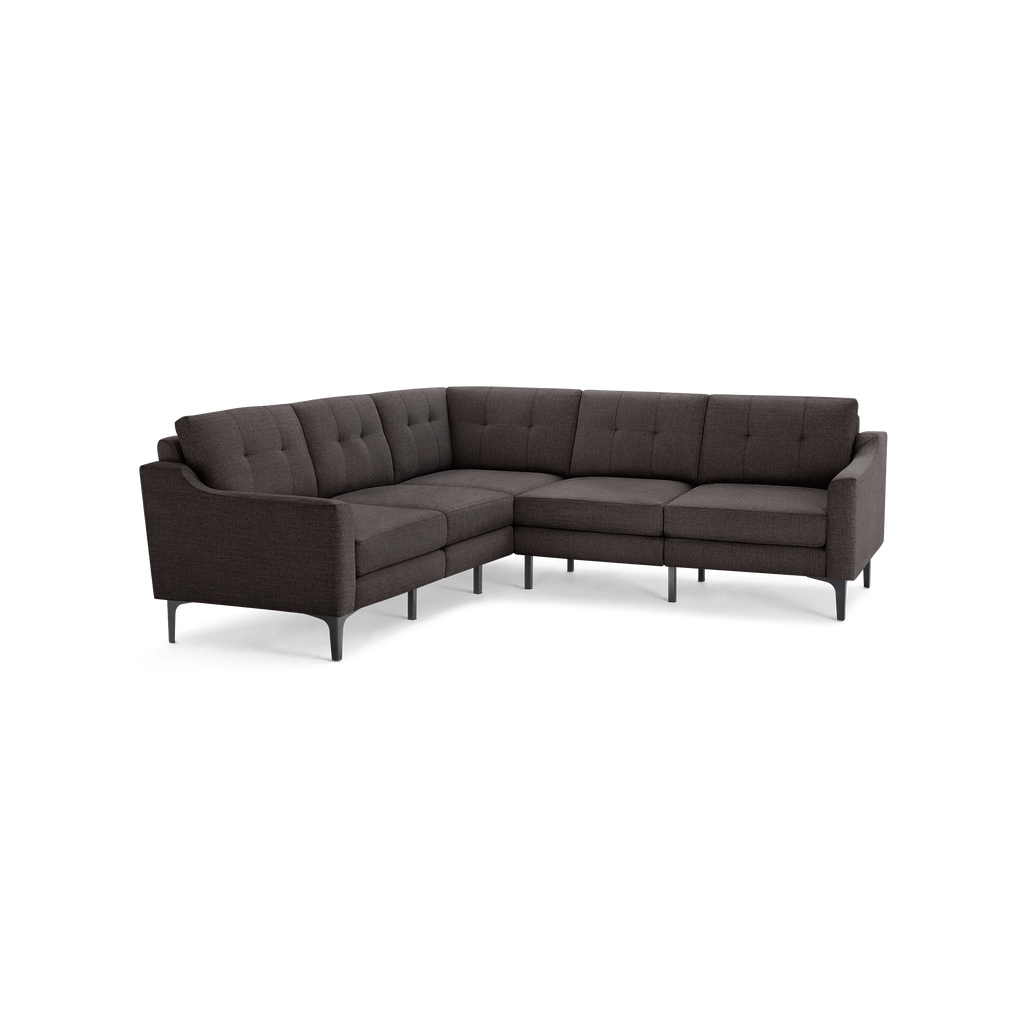 Dark gray fabric L-shaped sectional sofa with tufted back cushions and slim, angled legs.