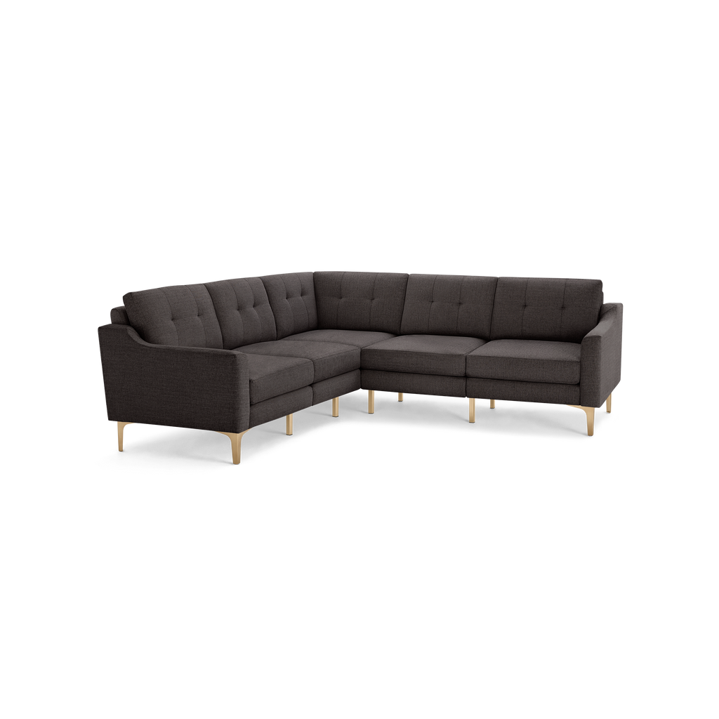 Dark gray upholstered L-shaped sectional sofa with tufted back cushions and slim light wooden legs.