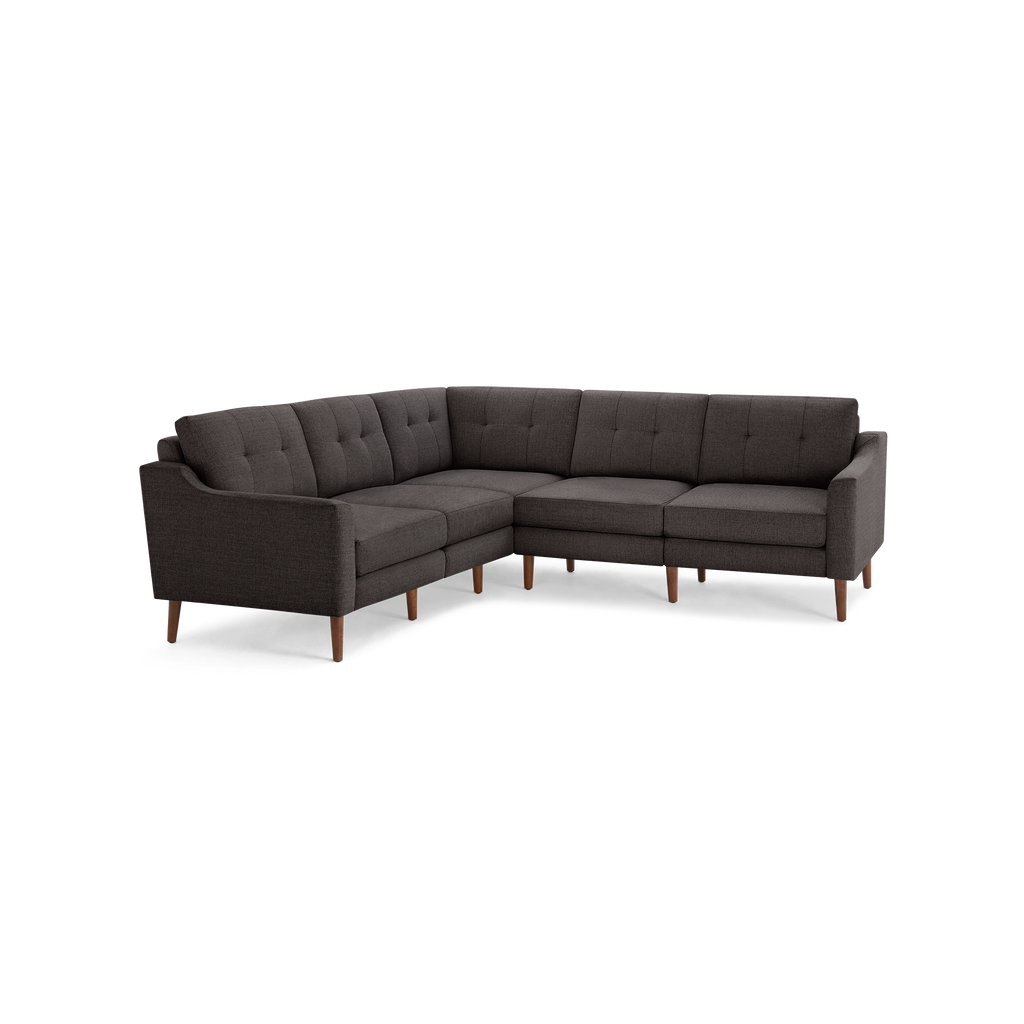 Dark gray fabric L-shaped sectional sofa with tufted back cushions and wooden legs, modern mid-century design.