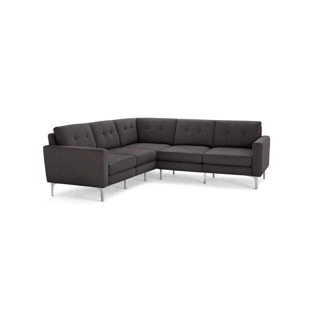 Dark gray upholstered L-shaped sectional sofa with tufted back cushions and sleek silver metal legs on a black background.
