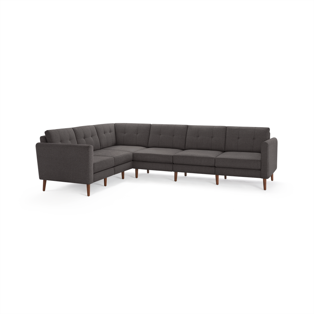 Dark gray tufted fabric sectional sofa with wooden legs, featuring a modern L-shape design with straight arms.