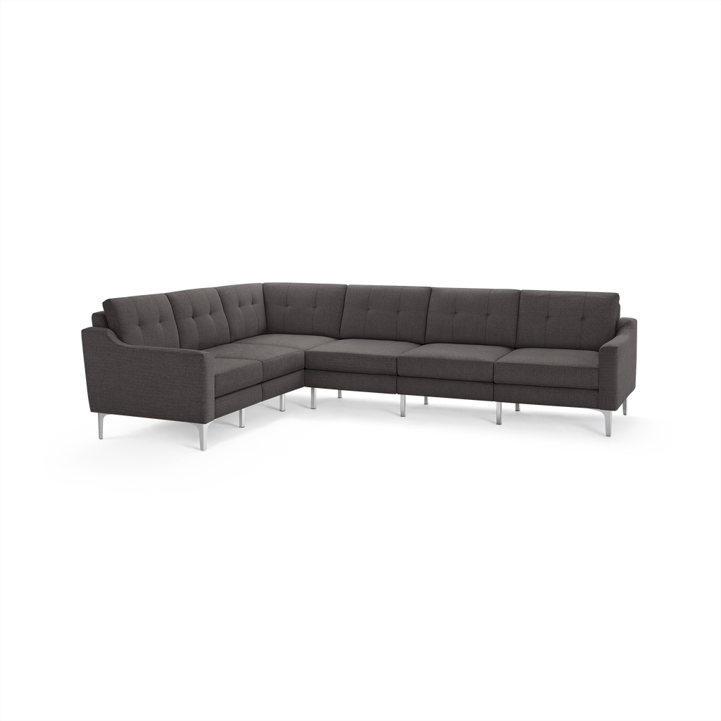 Modern dark gray fabric sectional sofa with tufted back cushions, curved armrests, and sleek metal legs.