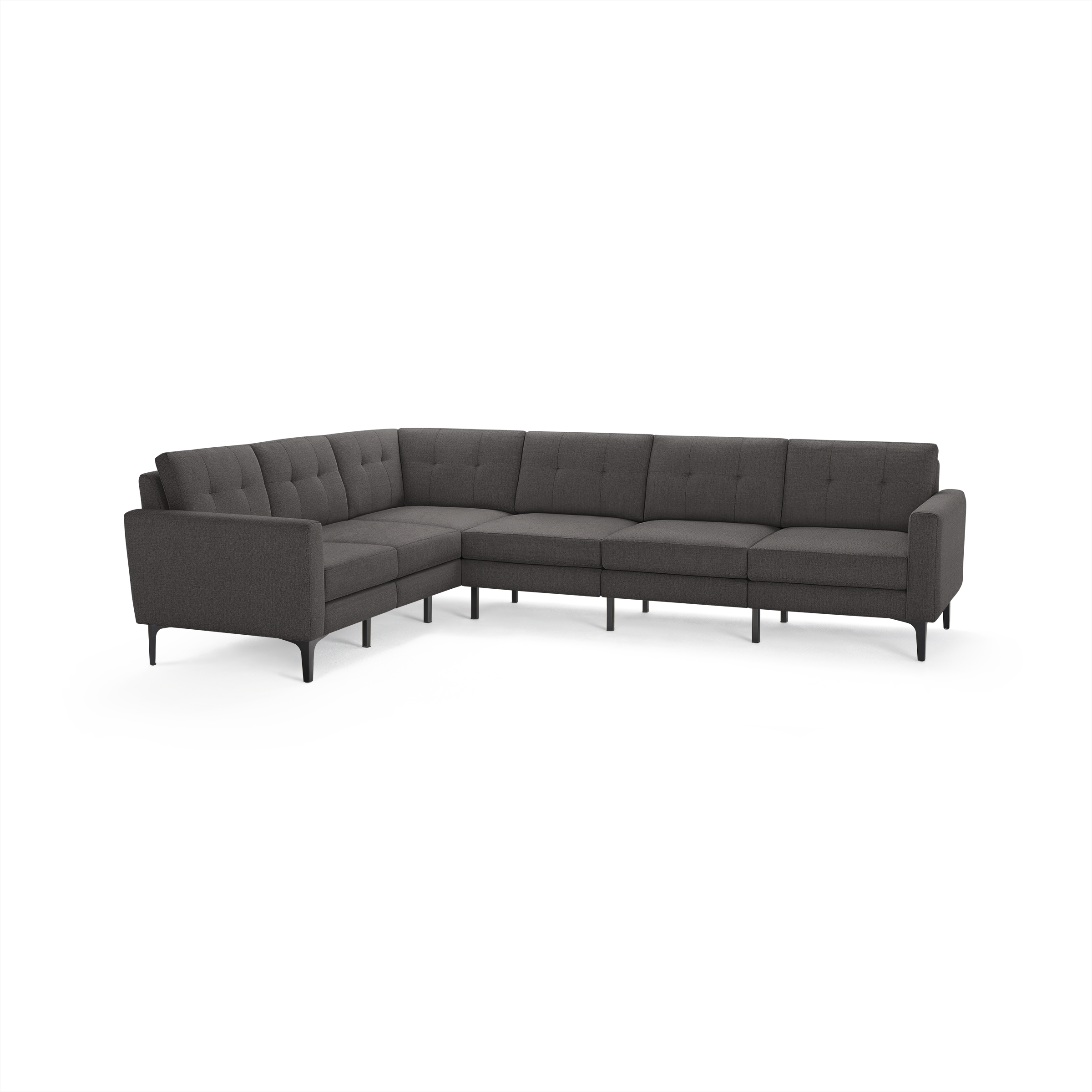 Large dark gray L-shaped sectional sofa with tufted back cushions and slim black legs on white background.