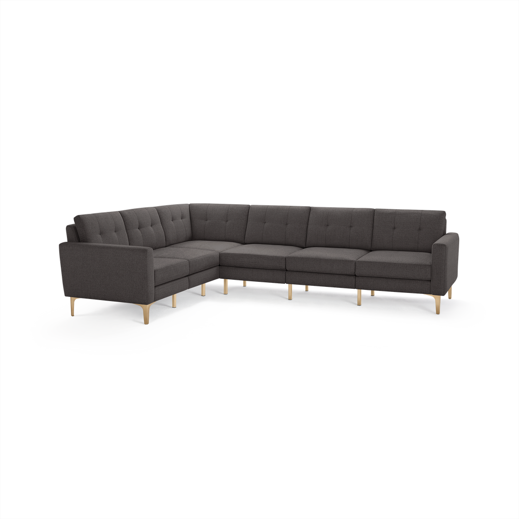 Dark gray L-shaped sectional sofa with tufted back cushions and light wooden angled legs.
