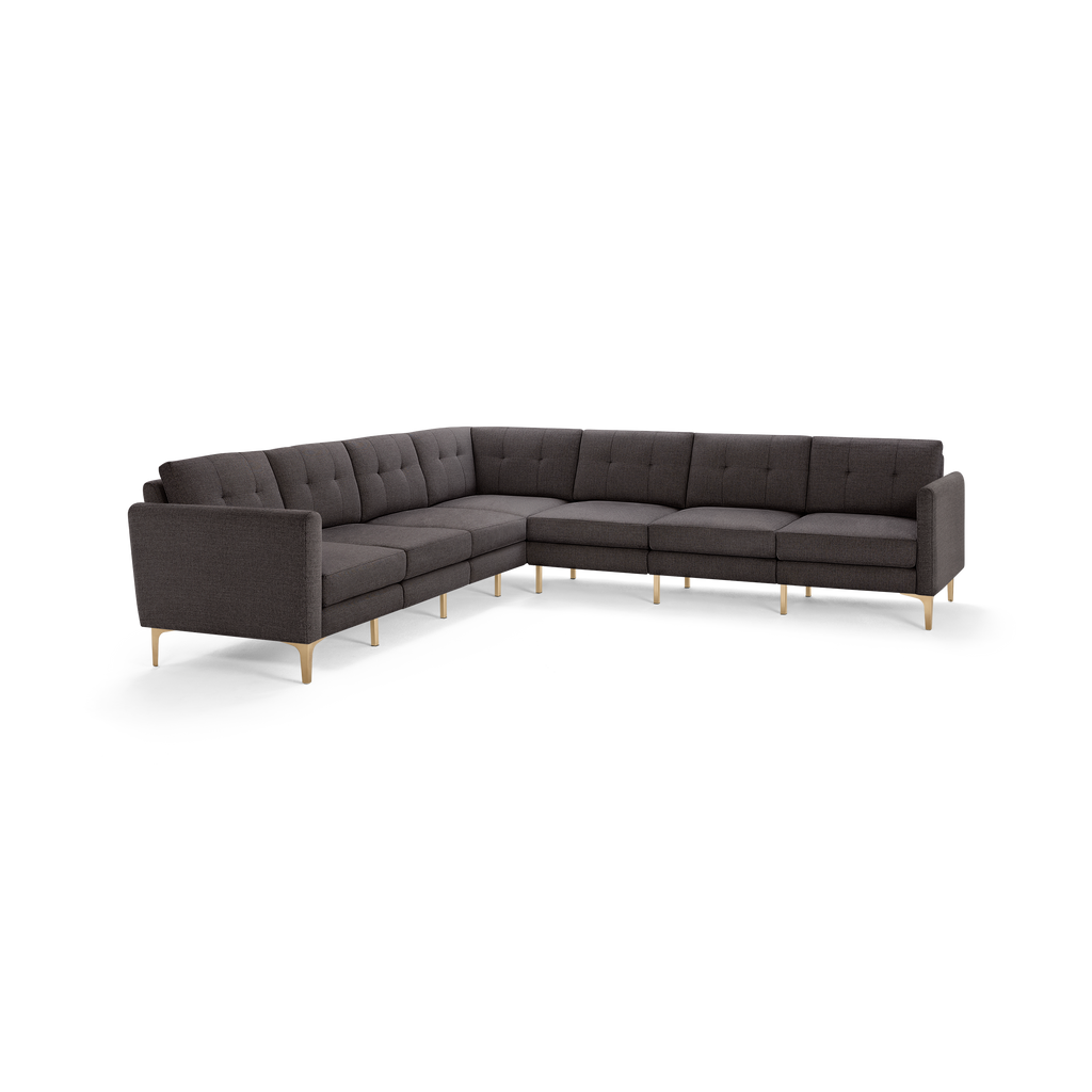 Large modern L-shaped sectional sofa with dark grey tufted fabric upholstery and light wooden legs.