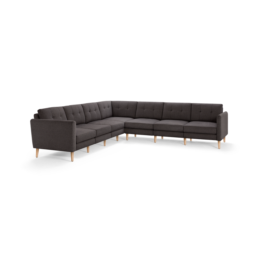 Modern dark gray fabric L-shaped sectional sofa with button-tufted back cushions and light wooden legs.