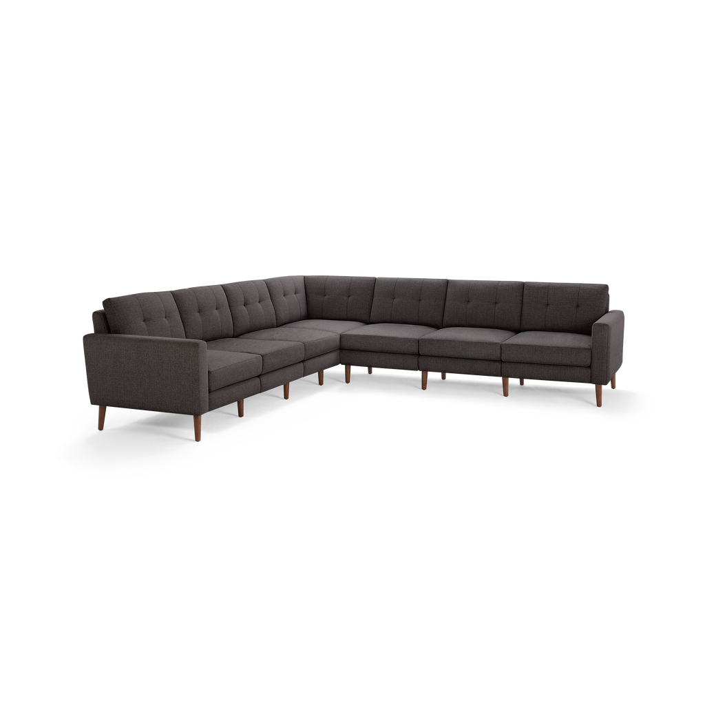 Dark gray fabric L-shaped sectional sofa with tufted back cushions and wooden legs, modern mid-century design.