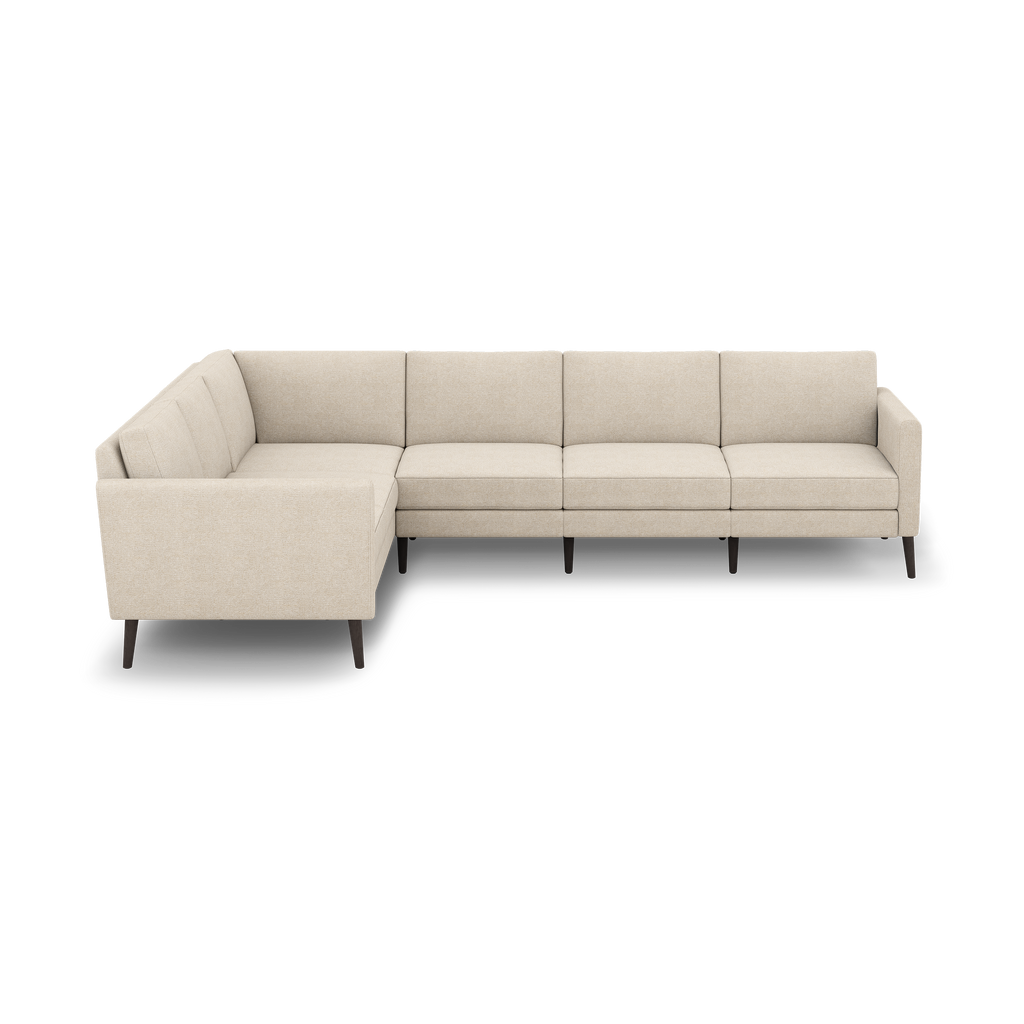 Beige L-shaped sectional sofa with clean lines, tufted back cushions, and dark wooden tapered legs, shown against a black background.