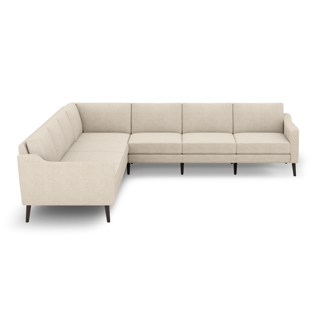 Beige fabric L-shaped sectional sofa with clean lines, tufted cushions, low arms, and dark wooden tapered legs.