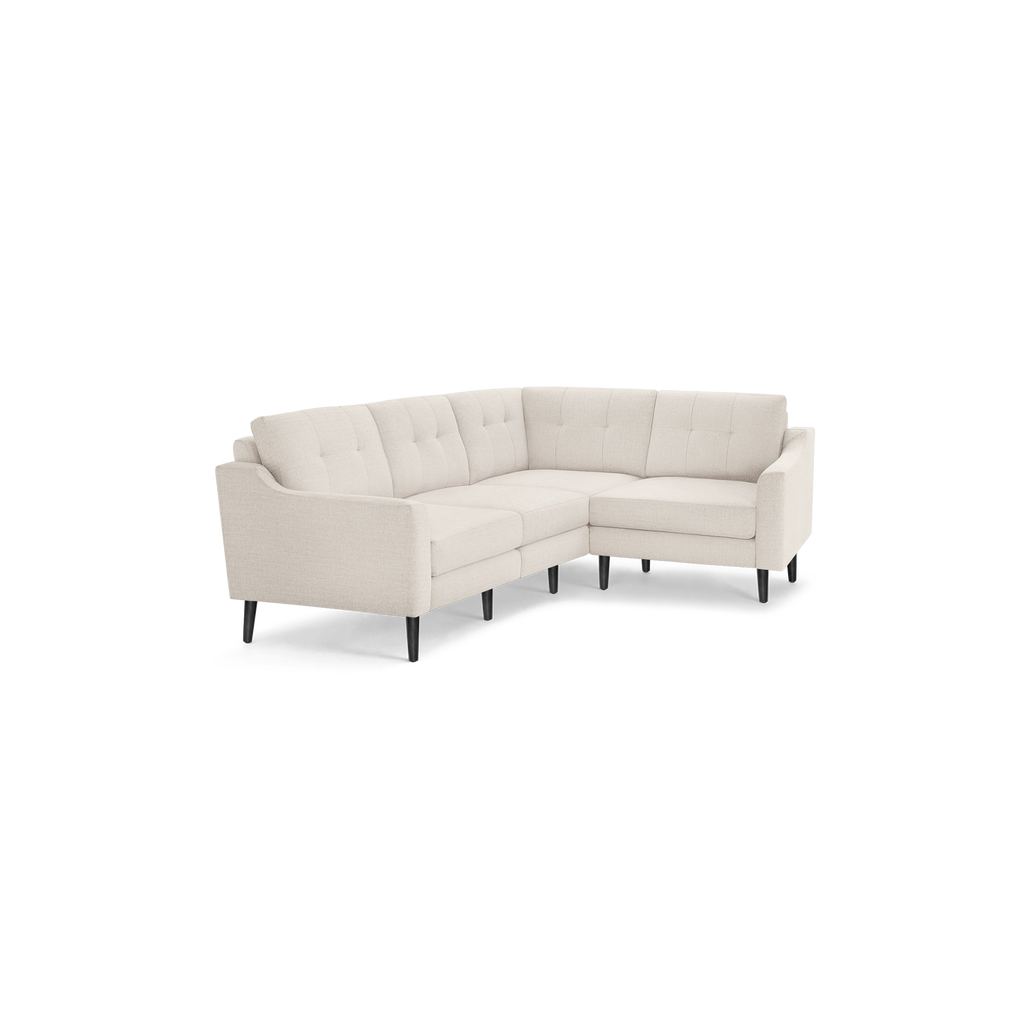 Cream-colored sectional sofa with tufted back cushions, clean lines, and black tapered wooden legs, designed for modern living spaces.