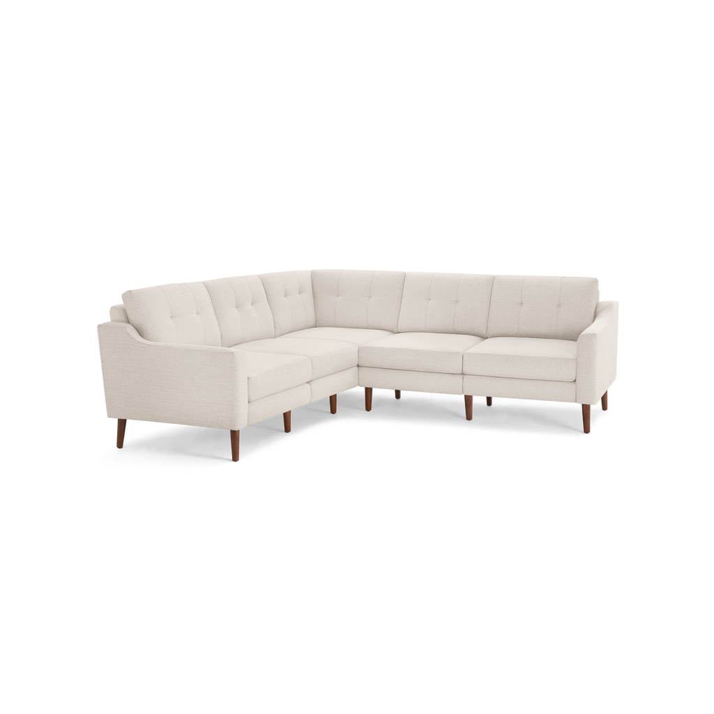 Light beige L-shaped sectional sofa with tufted back cushions and tapered wooden legs, featuring clean mid-century modern design.