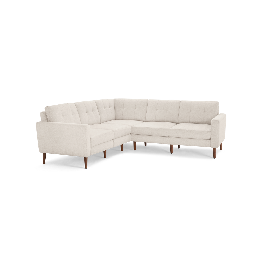 Light beige L-shaped sectional sofa with tufted back cushions and wooden tapered legs, modern mid-century design.