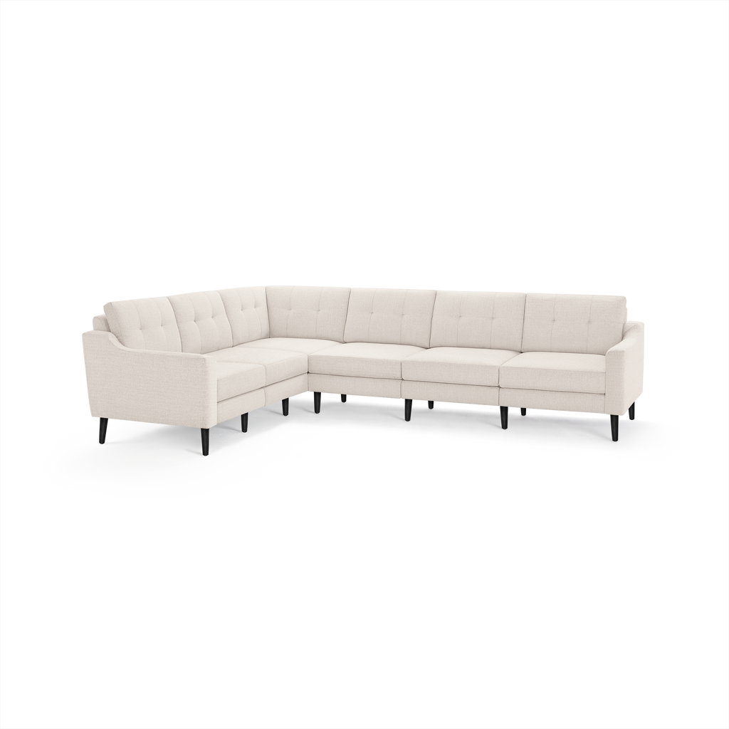 Light beige fabric sectional sofa with tufted back cushions, curved armrests, and black tapered legs.