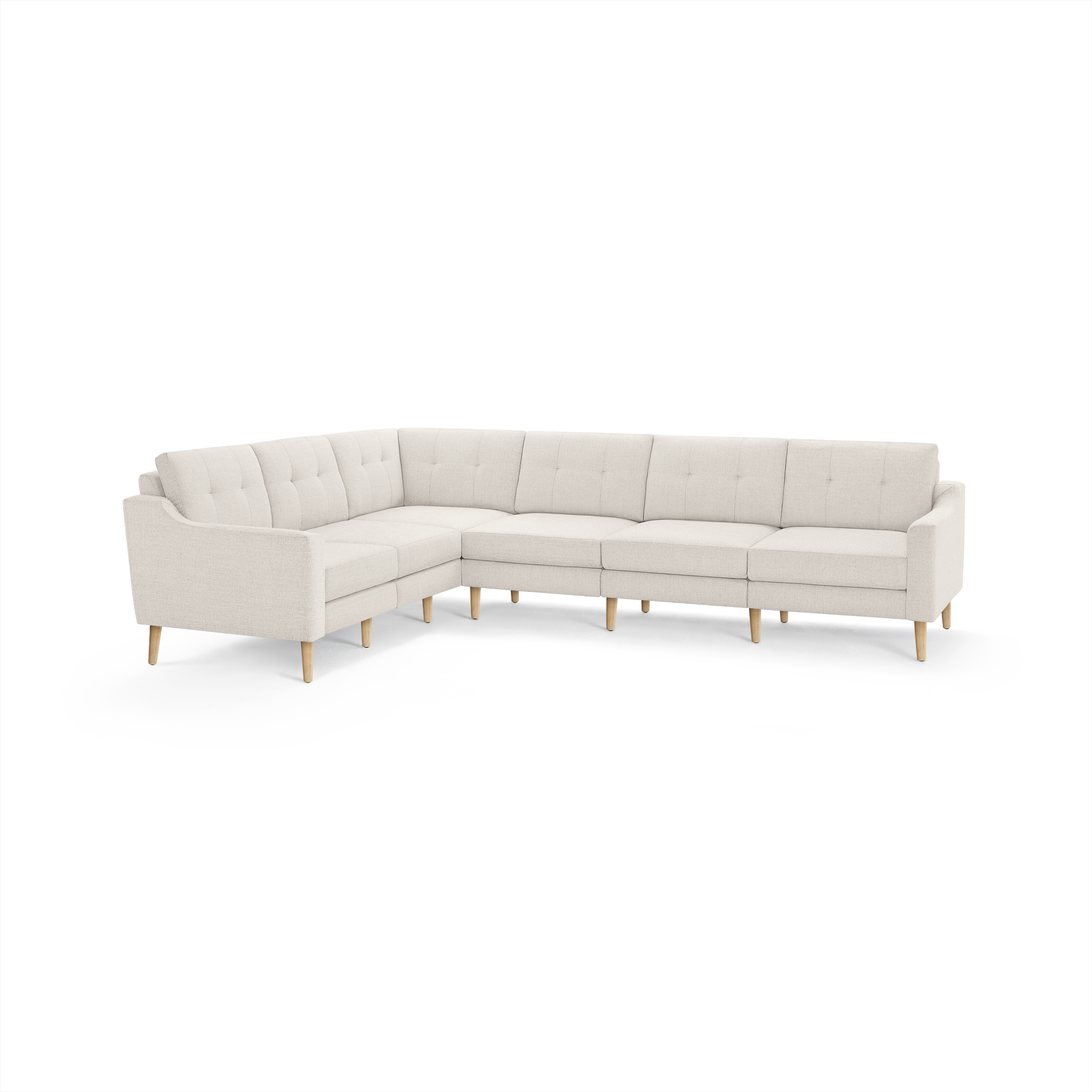 Large L-shaped sectional sofa upholstered in light beige fabric with tufted backrest cushions and wooden legs.