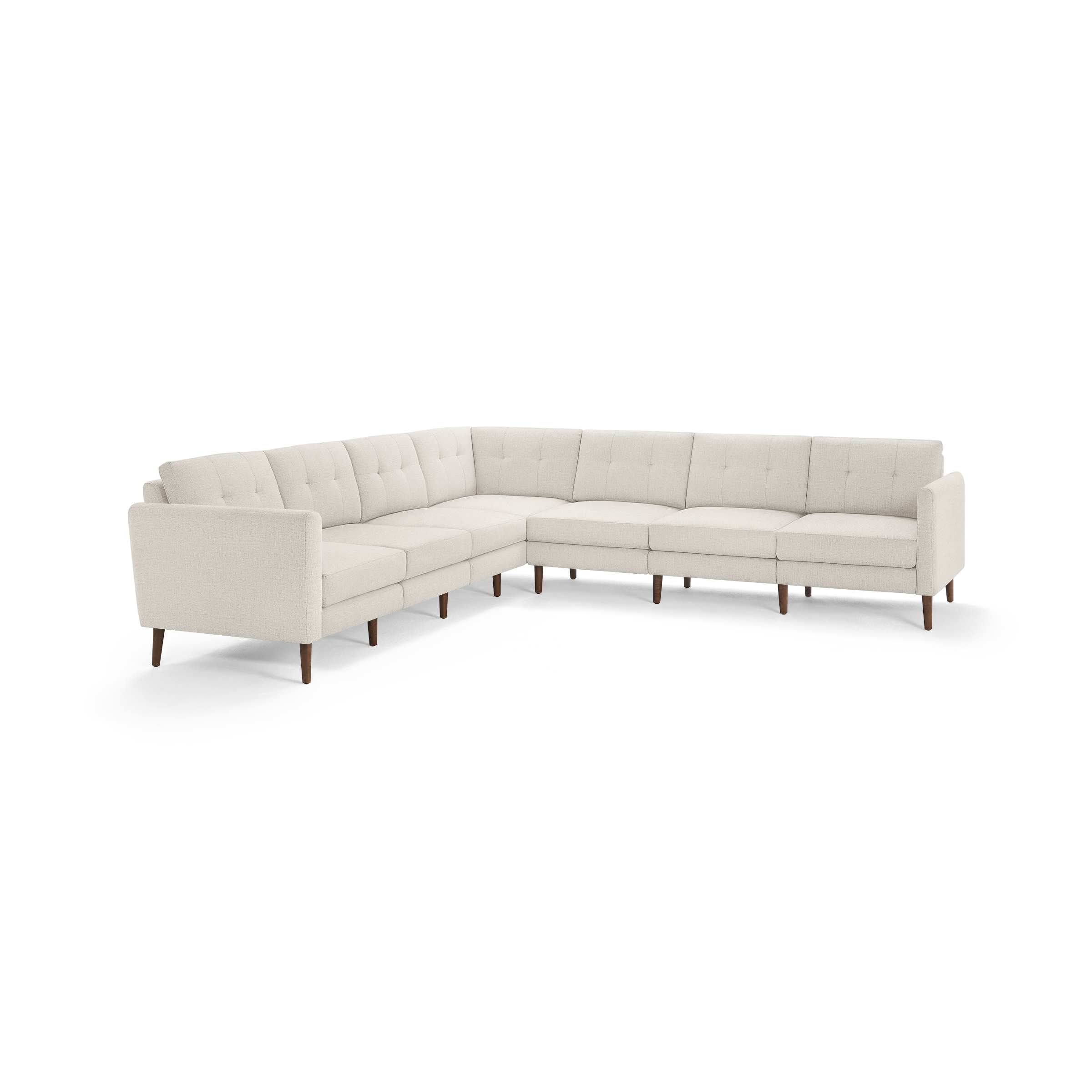 Large L-shaped sectional sofa in light beige fabric with tufted back cushions and wooden tapered legs.