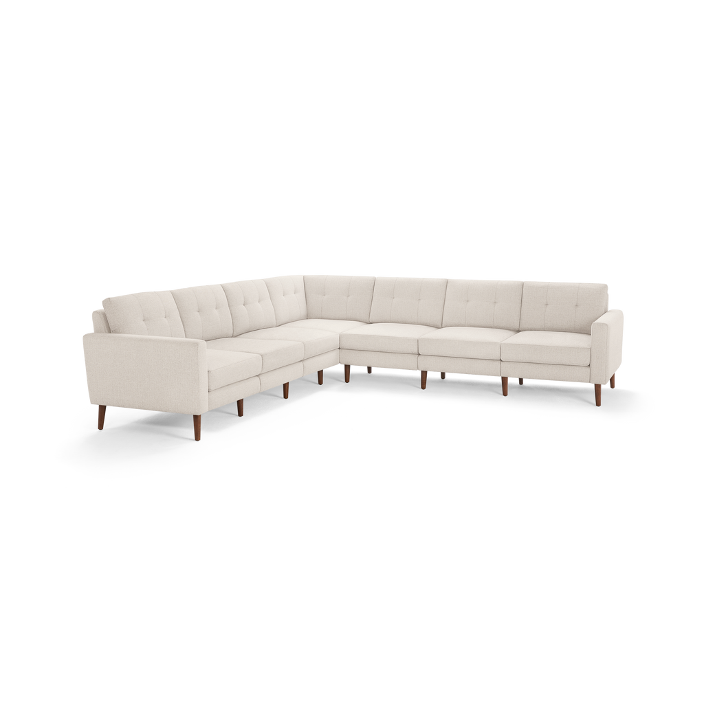 Cream-colored L-shaped sectional sofa with tufted cushions and wooden legs on a white background.