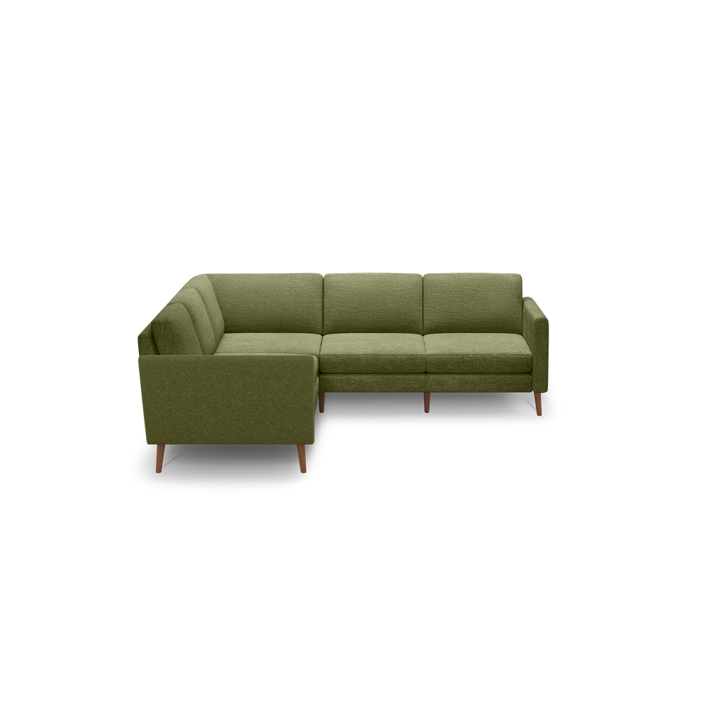 Olive green L-shaped sectional sofa with mid-century wooden legs and tufted seat cushions on black background.