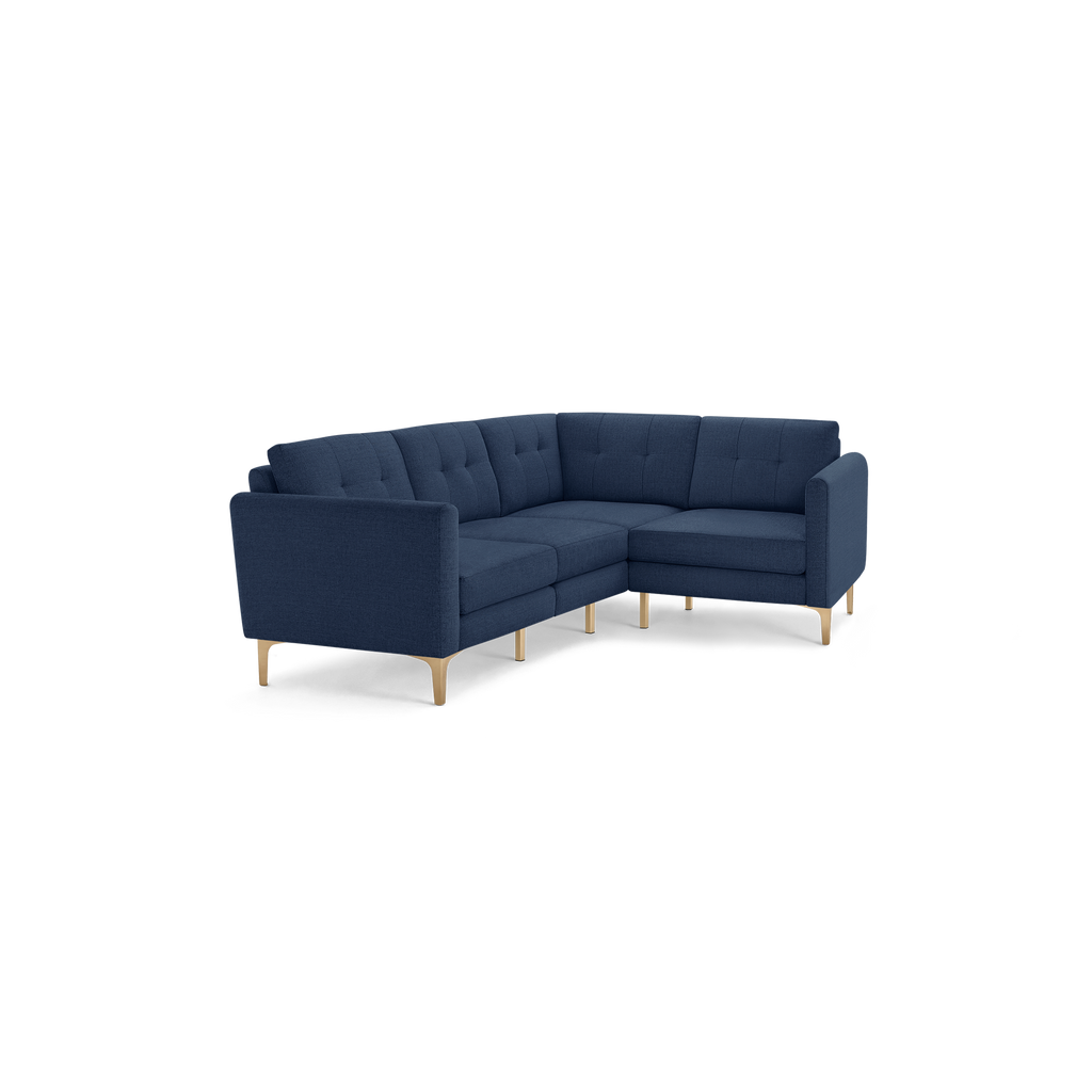 Modern L-shaped navy blue fabric sectional sofa with tufted back cushions and light wooden legs, designed for spacious seating.