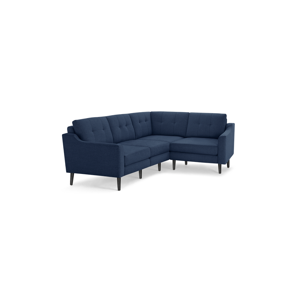 Modern navy blue fabric sectional sofa with tufted back cushions and slender black wooden legs, designed for corner placement.