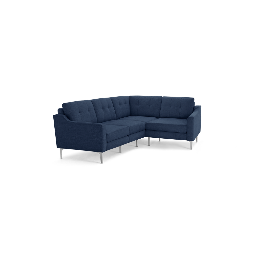 Modern L-shaped sectional sofa with navy blue tufted fabric upholstery and slim silver metal legs, featuring cushioned seats and backrests.