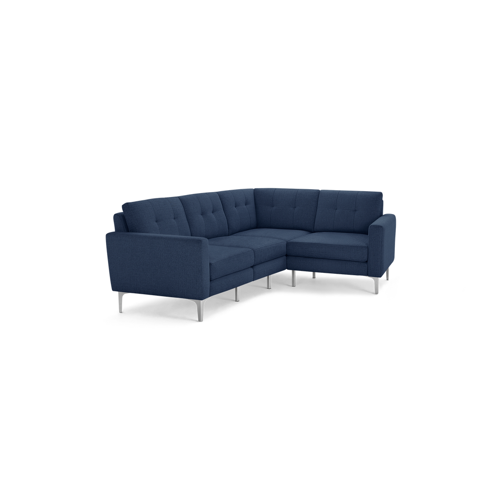 Modern navy blue fabric sectional sofa with tufted back cushions, slim metal legs, and clean-lined armrests.