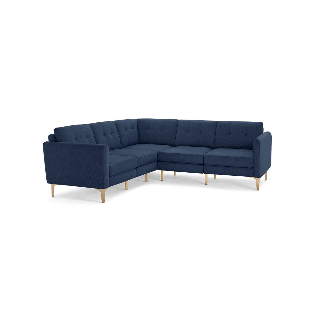 Dark blue fabric sectional sofa with tufted cushions and light wooden legs, designed in an L-shape for corner seating.