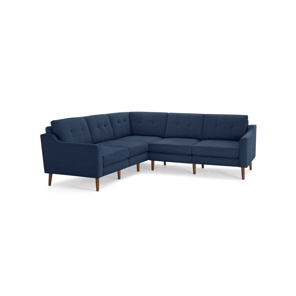 Navy blue L-shaped sectional sofa with tufted back cushions and wooden legs, featuring a mid-century modern design.