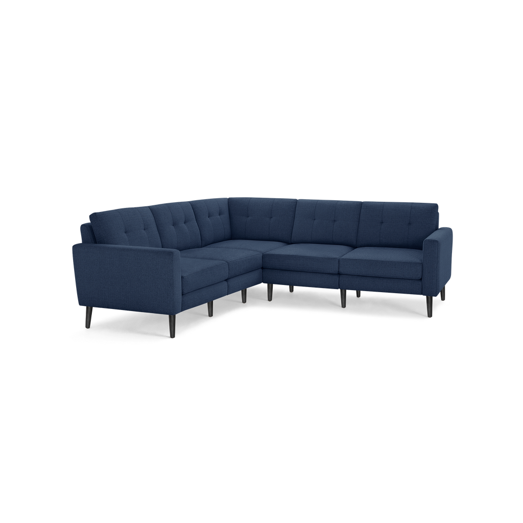 Navy blue fabric L-shaped sectional sofa with tufted back cushions and black tapered wooden legs.