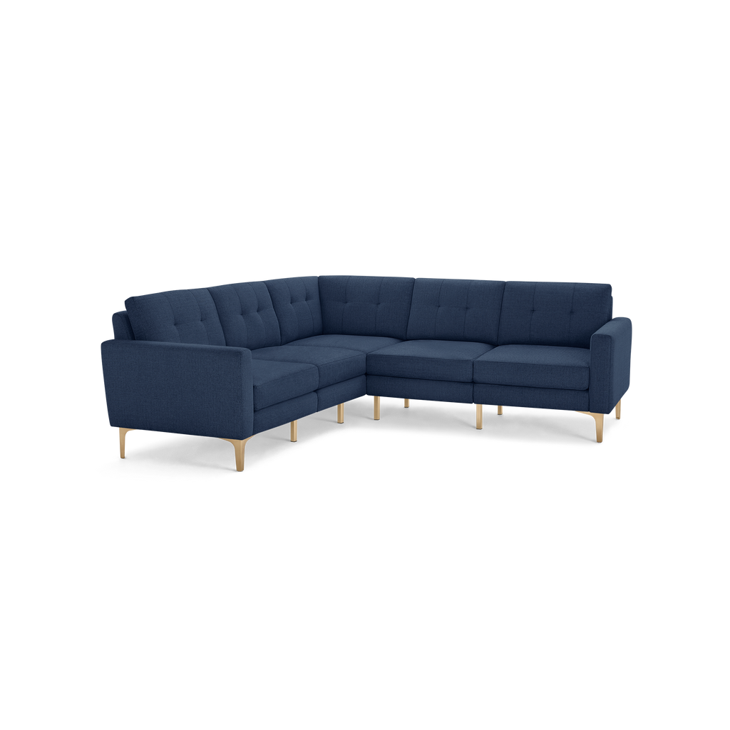Modern navy blue L-shaped sectional sofa with tufted cushions and light wooden legs, designed for spacious seating.