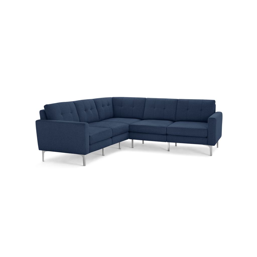 Modern L-shaped sectional sofa in dark blue fabric with tufted cushions and silver metal legs, designed for corner seating.
