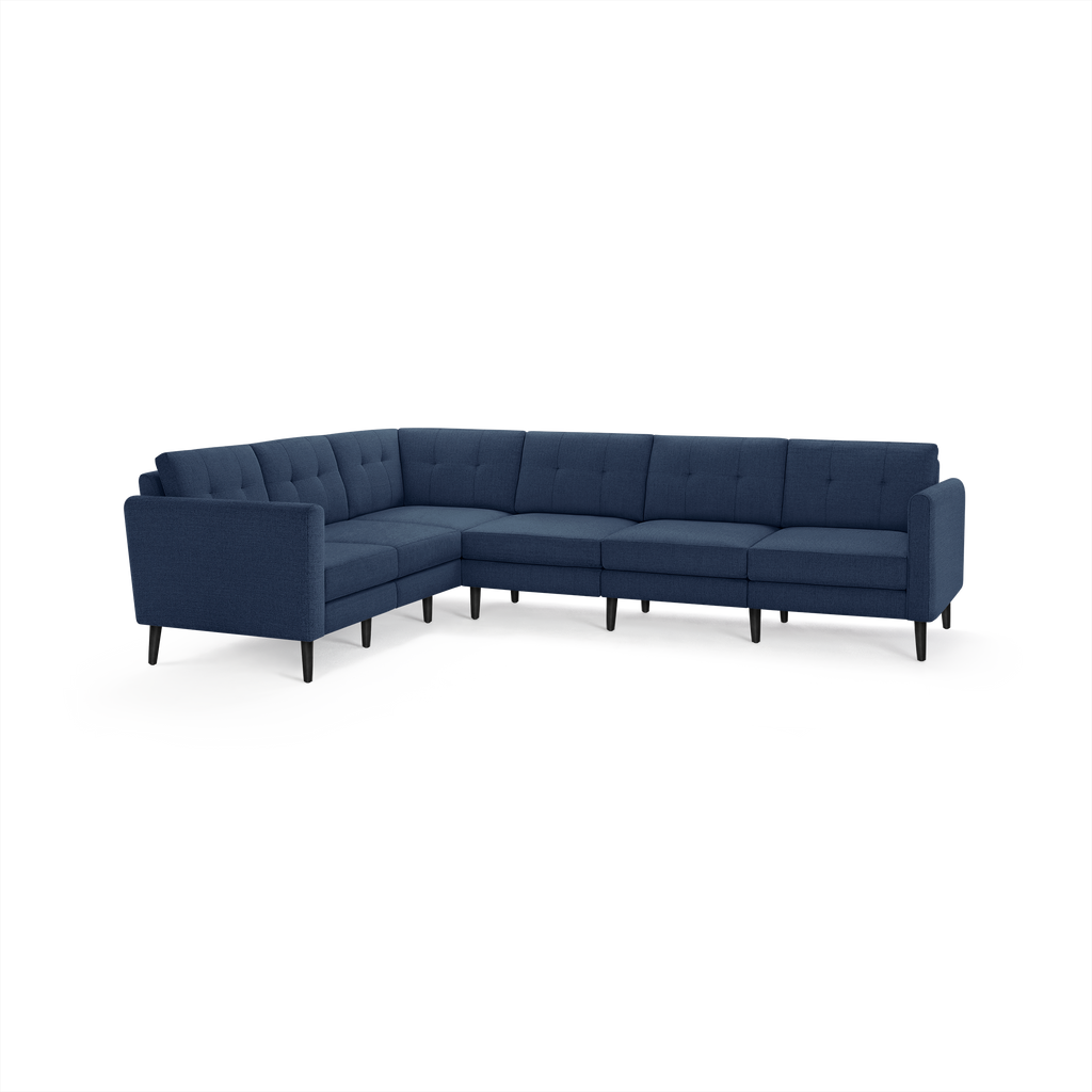 Navy blue upholstered sectional sofa with tufted back cushions, slim armrests, and black tapered legs, in an L-shaped configuration.