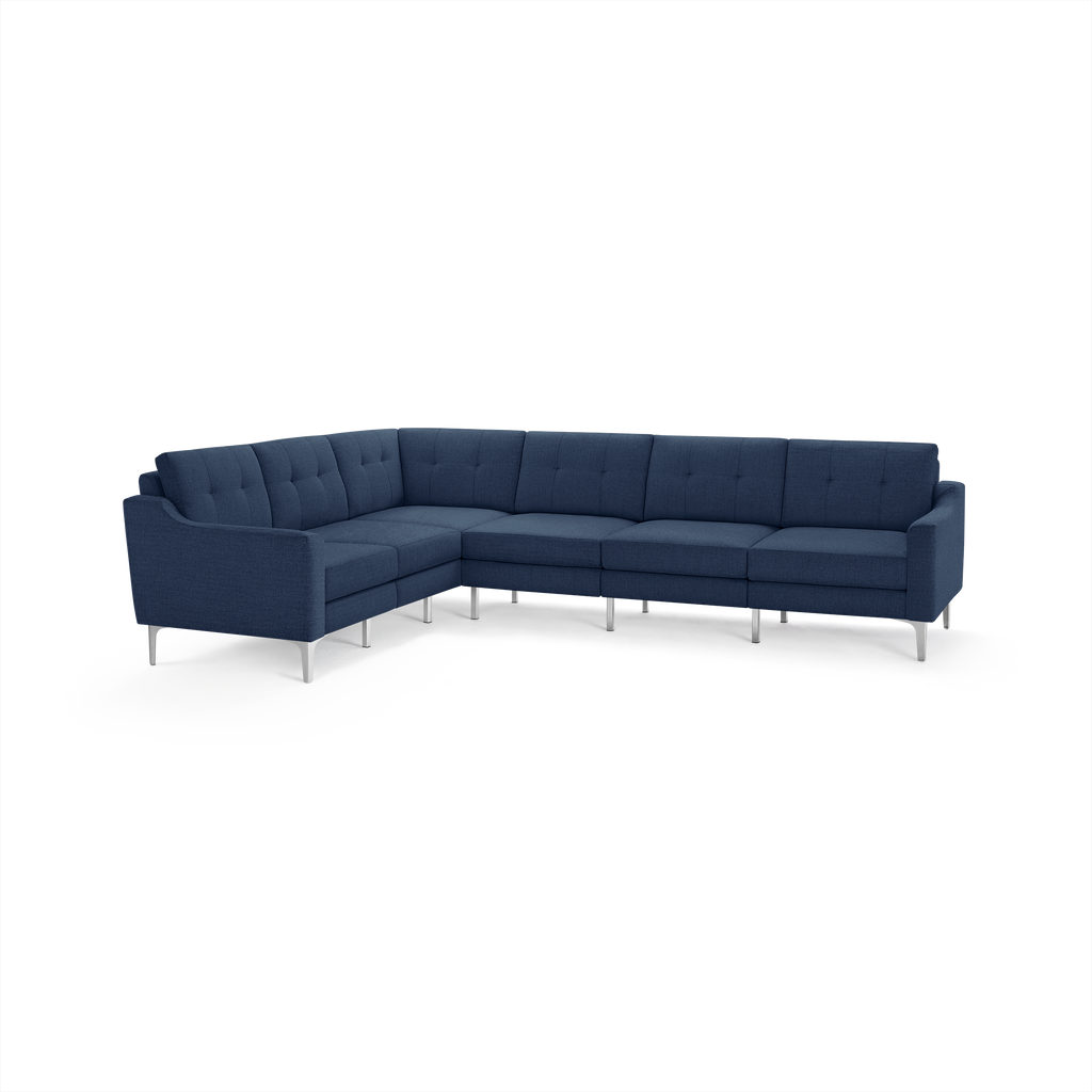 Modern L-shaped sectional sofa in navy blue fabric with tufted back cushions and slim silver metal legs.