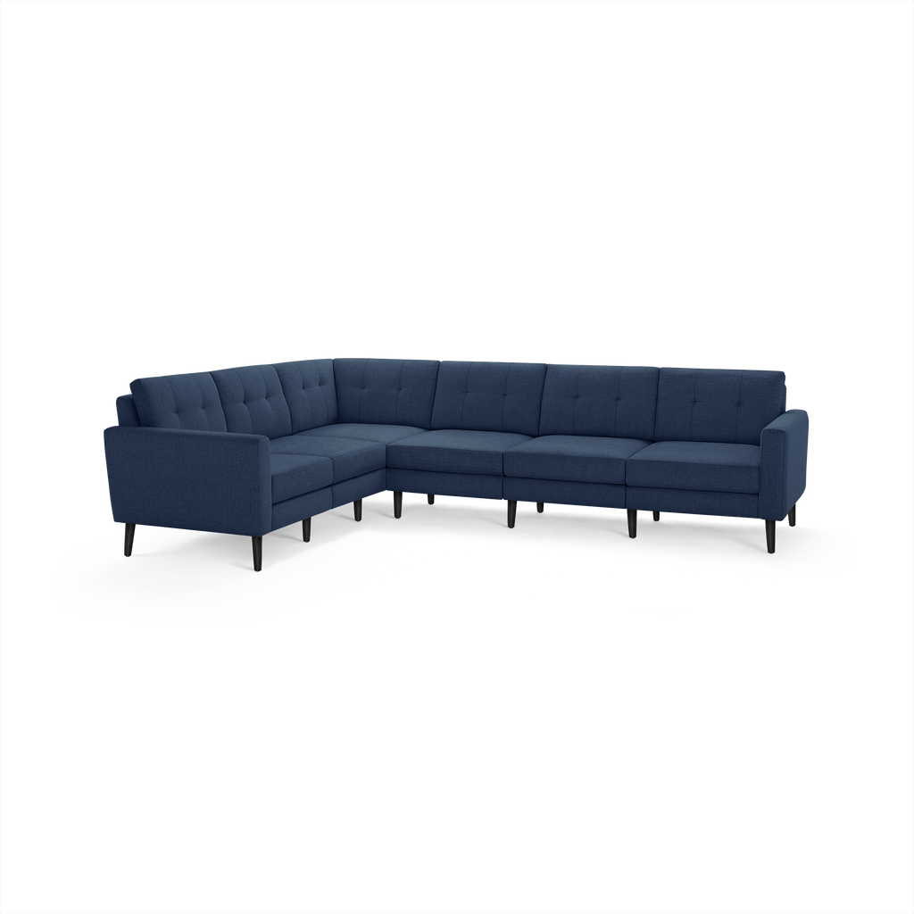 Modern L-shaped sectional sofa in dark blue fabric with tufted back cushions and black angled legs.