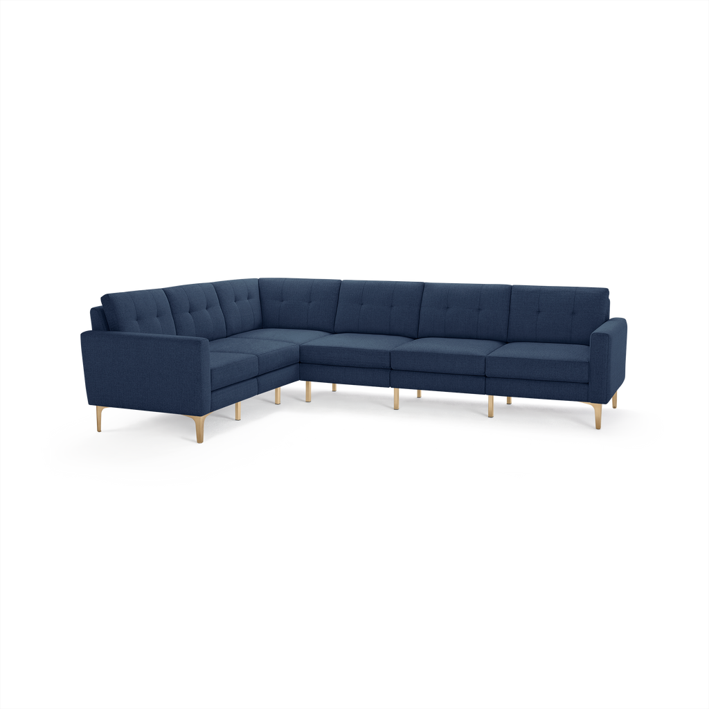 Modern navy blue L-shaped sectional sofa with tufted back cushions and light wooden tapered legs, designed for spacious seating and comfort.