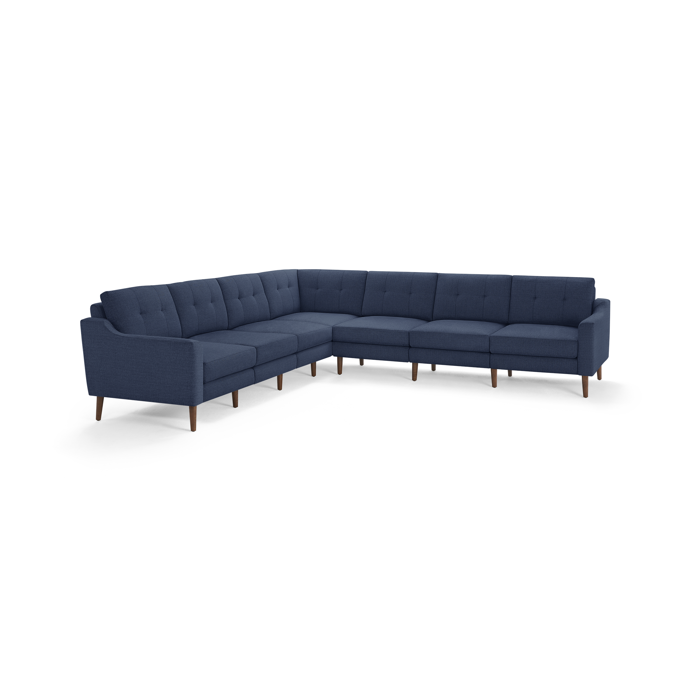 Large L-shaped sectional sofa in dark blue fabric with tufted back cushions and wooden tapered legs.