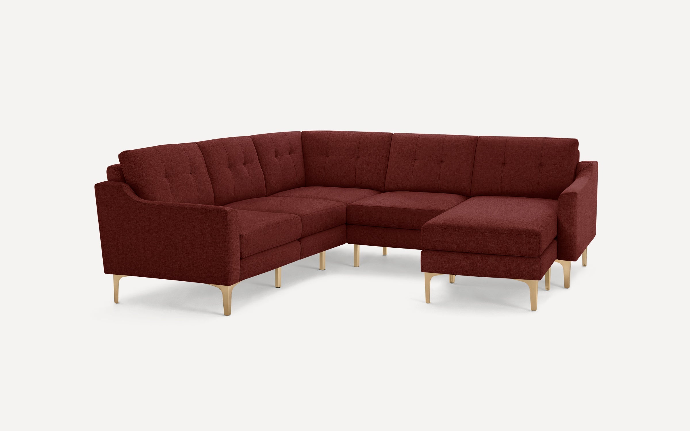 Modern sectional sofa in deep red fabric with tufted cushions and light wooden legs, designed for comfort and style.