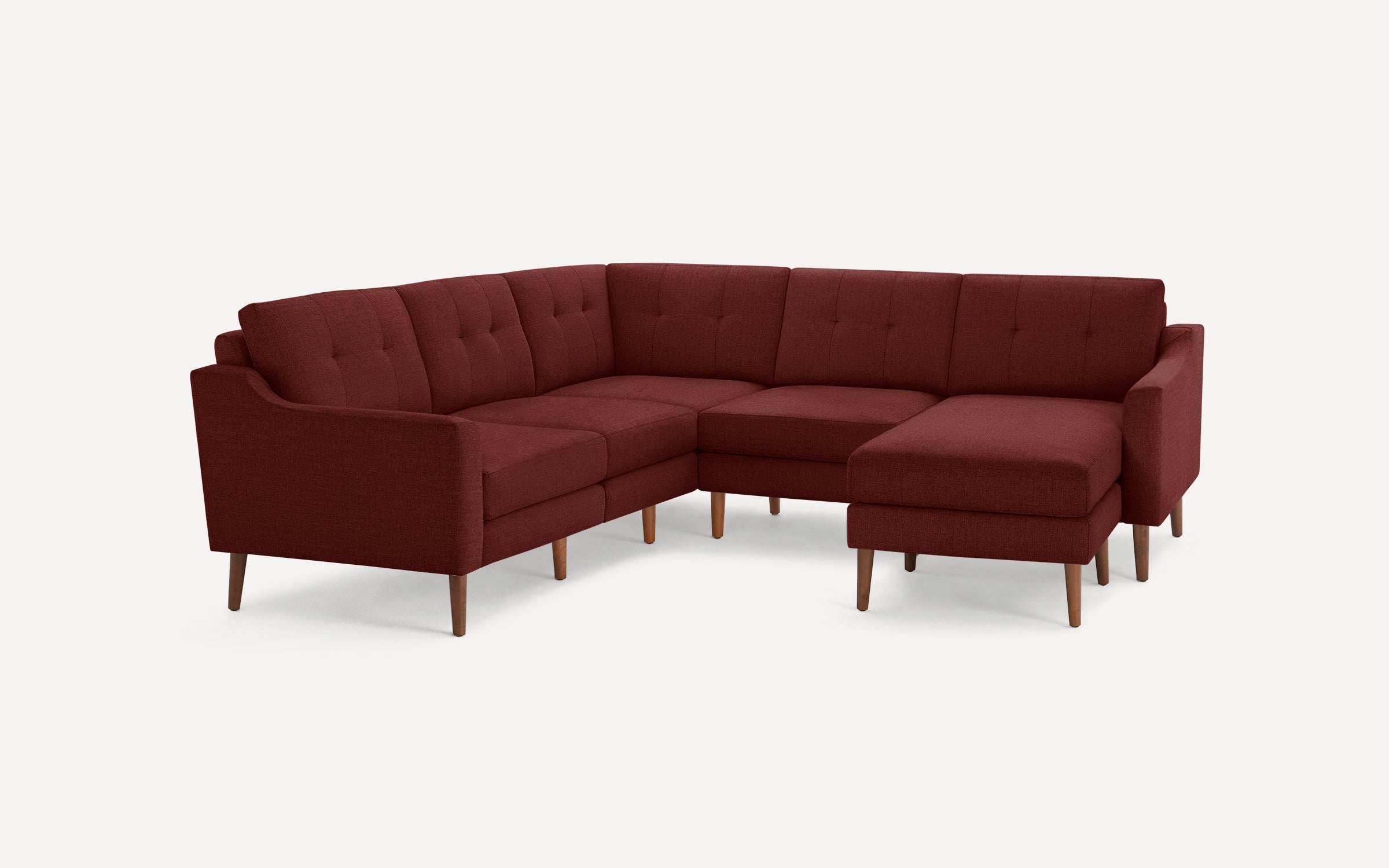 Mid-century style sectional sofa with deep red fabric upholstery, tufted back cushions, and wooden tapered legs, featuring a right-side chaise lounge.
