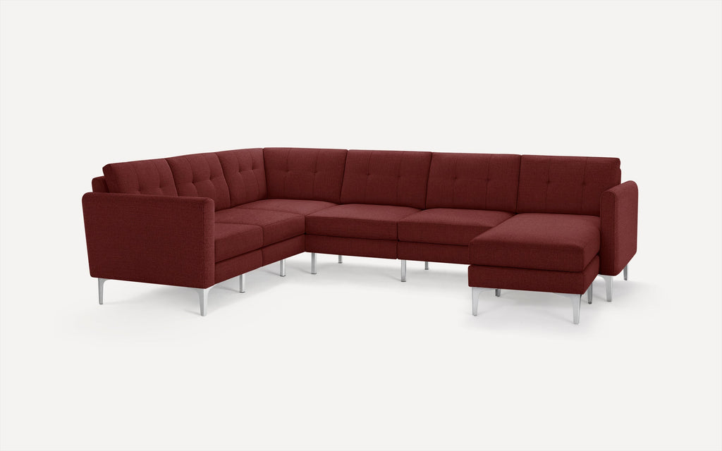 Modern L-shaped sectional sofa in deep red fabric with tufted back cushions and slim metal legs on white background.