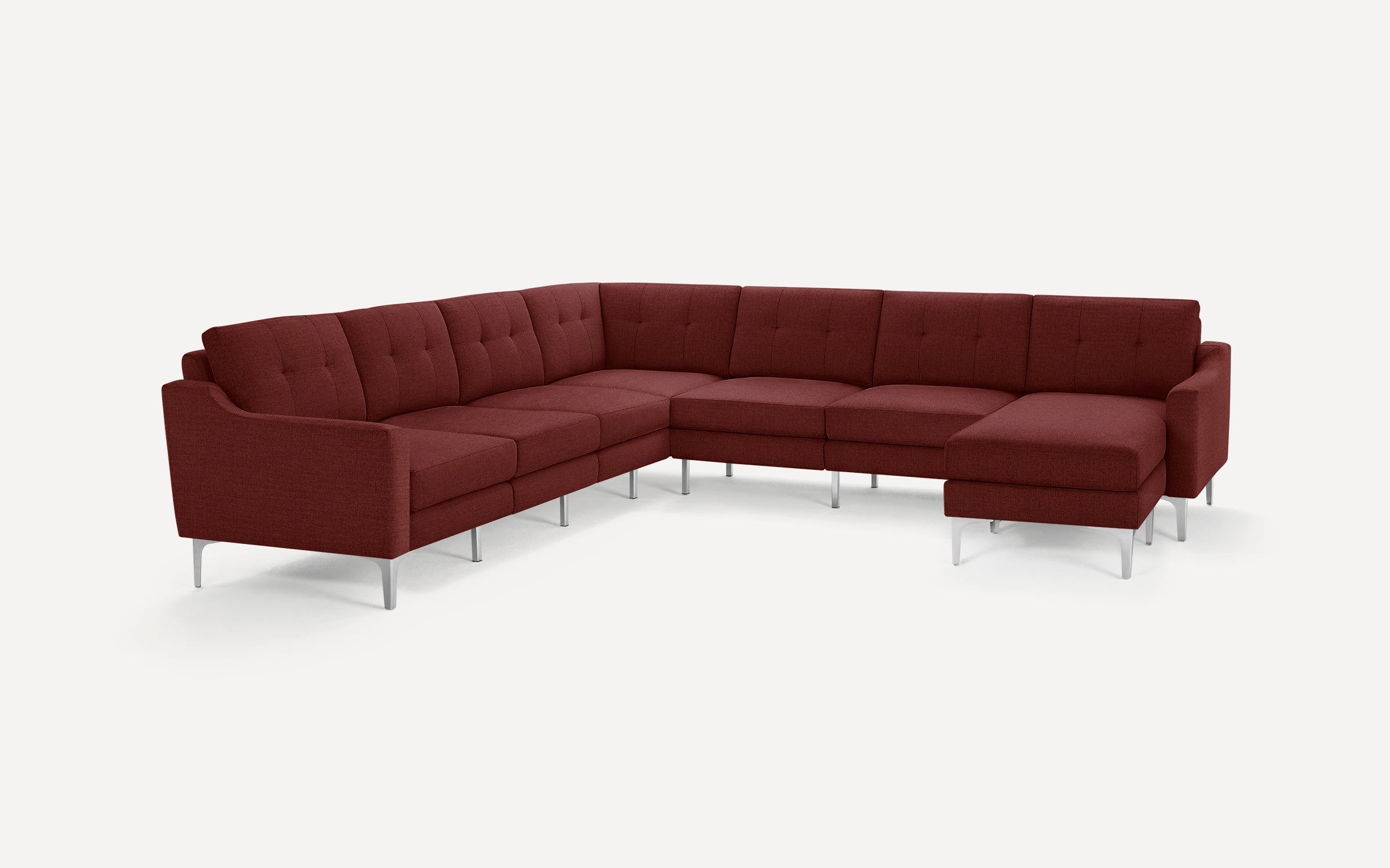 Large modern L-shaped sectional sofa in deep red fabric upholstery with tufted cushions and sleek silver metal legs, designed for spacious living areas.