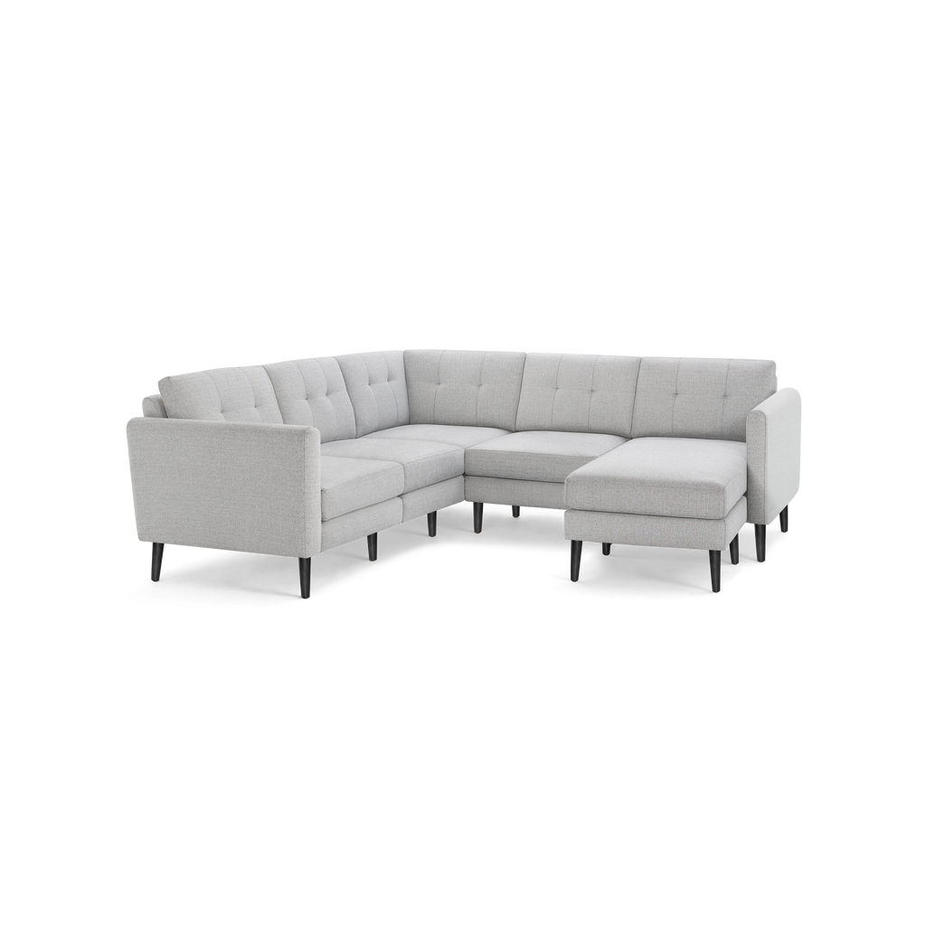 Light gray fabric L-shaped sectional sofa with button-tufted back cushions and dark wooden tapered legs, featuring a chaise lounge on the right side.