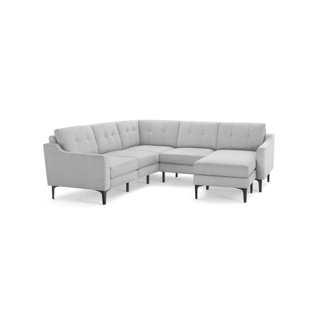 Light gray upholstered L-shaped sectional sofa with tufted back cushions and slim black legs.
