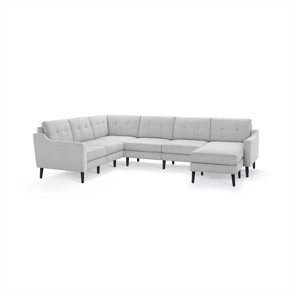 Light gray L-shaped sectional sofa with tufted back cushions and black slender wooden legs.