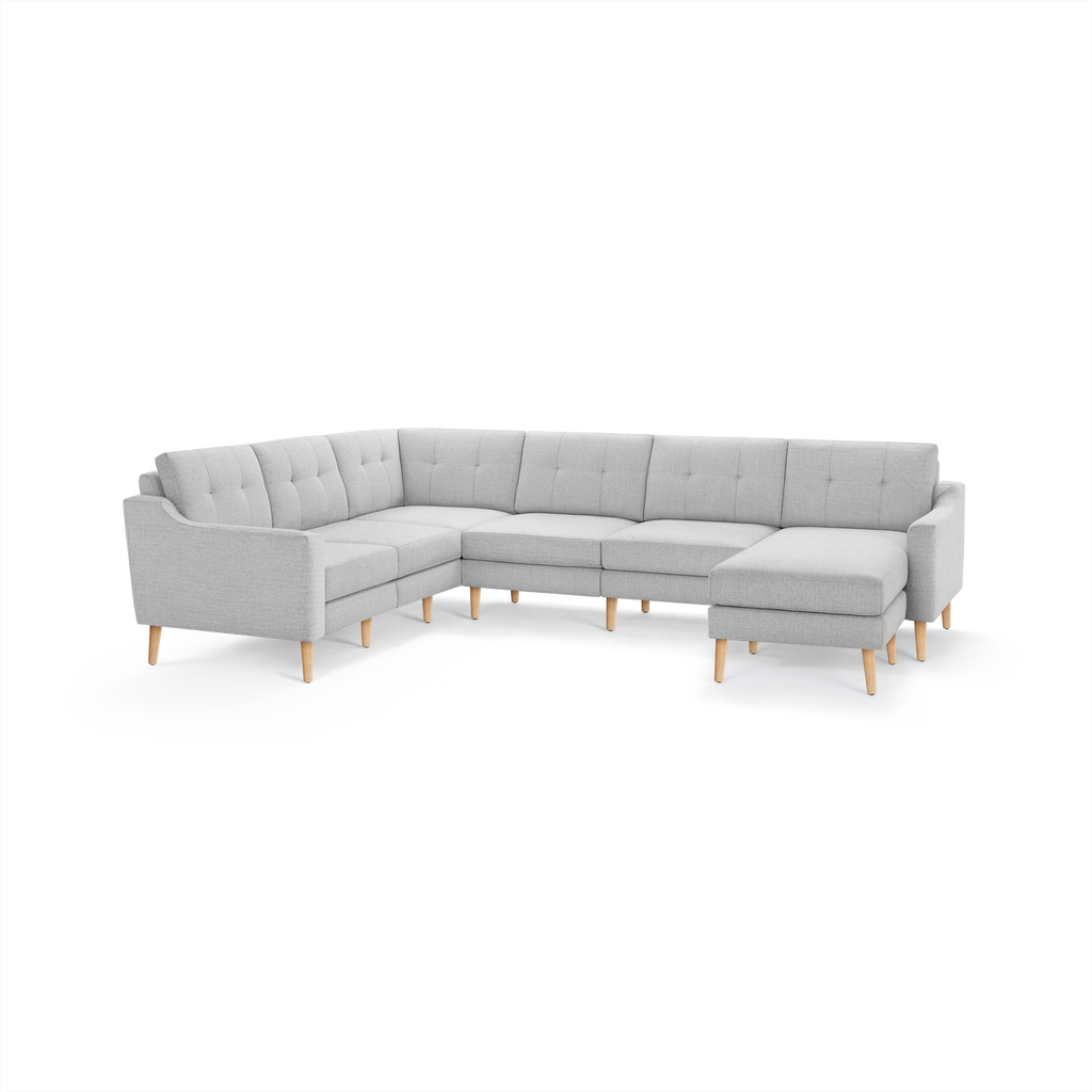 Light gray L-shaped sectional sofa with tufted cushions and wooden legs, featuring a chaise lounge on the right side.