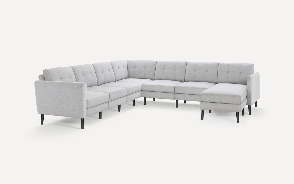 Light gray fabric L-shaped sectional sofa with tufted back cushions and black tapered wooden legs on white background.